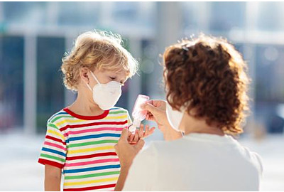 Zweite Corona-Welle: Mutter und Kind tragen Gesichtsmaske während des Ausbruchs von Coronavirus und Grippe